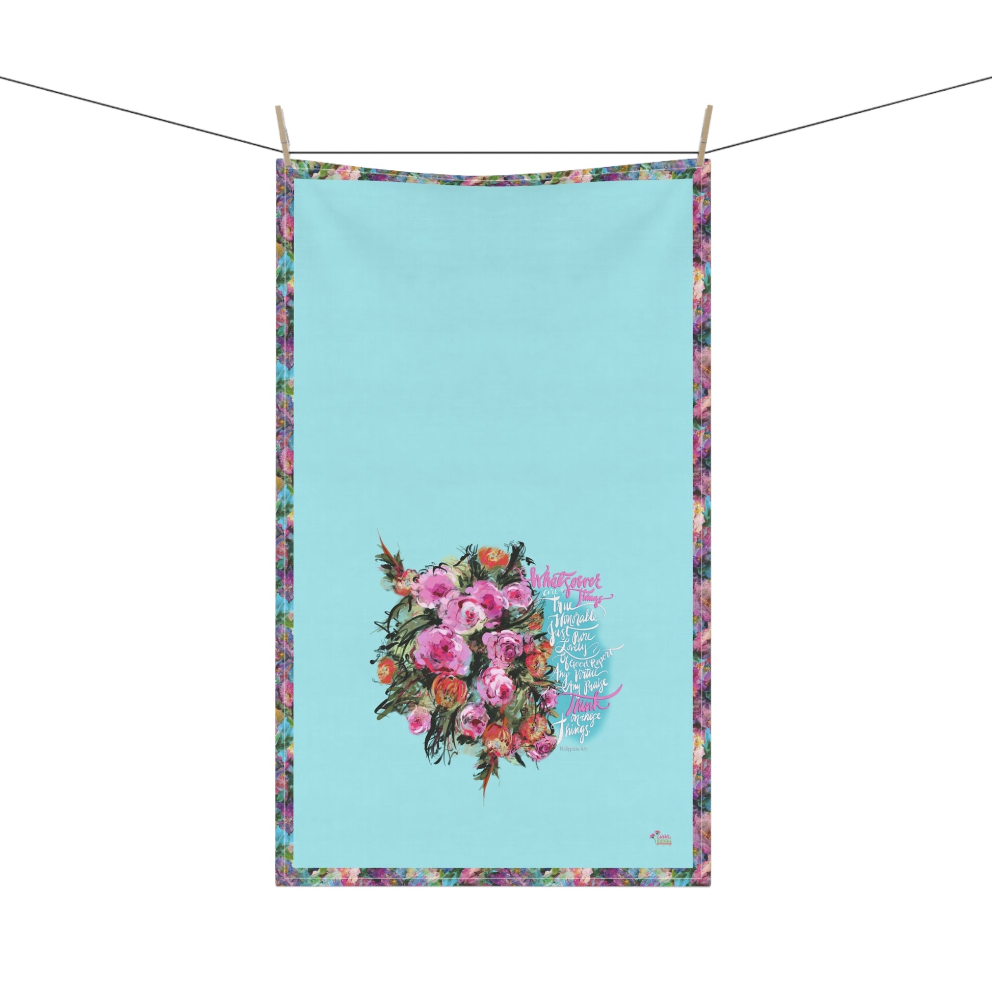 Floral kitchen towel with calligraphy Bible verse "Whatsoever things" on a blue background, hanging on a line.