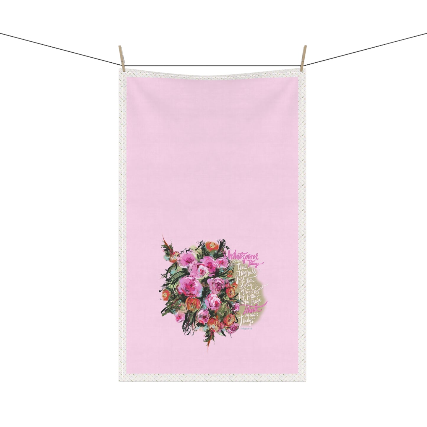 Pink kitchen tea towel with Bible verse "Whatsoever things" and floral design hanging on a line