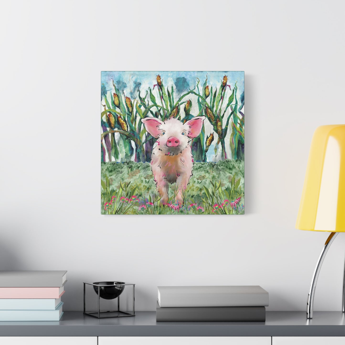 Canvas print of a pig in a field hanging on a wall above a desk.