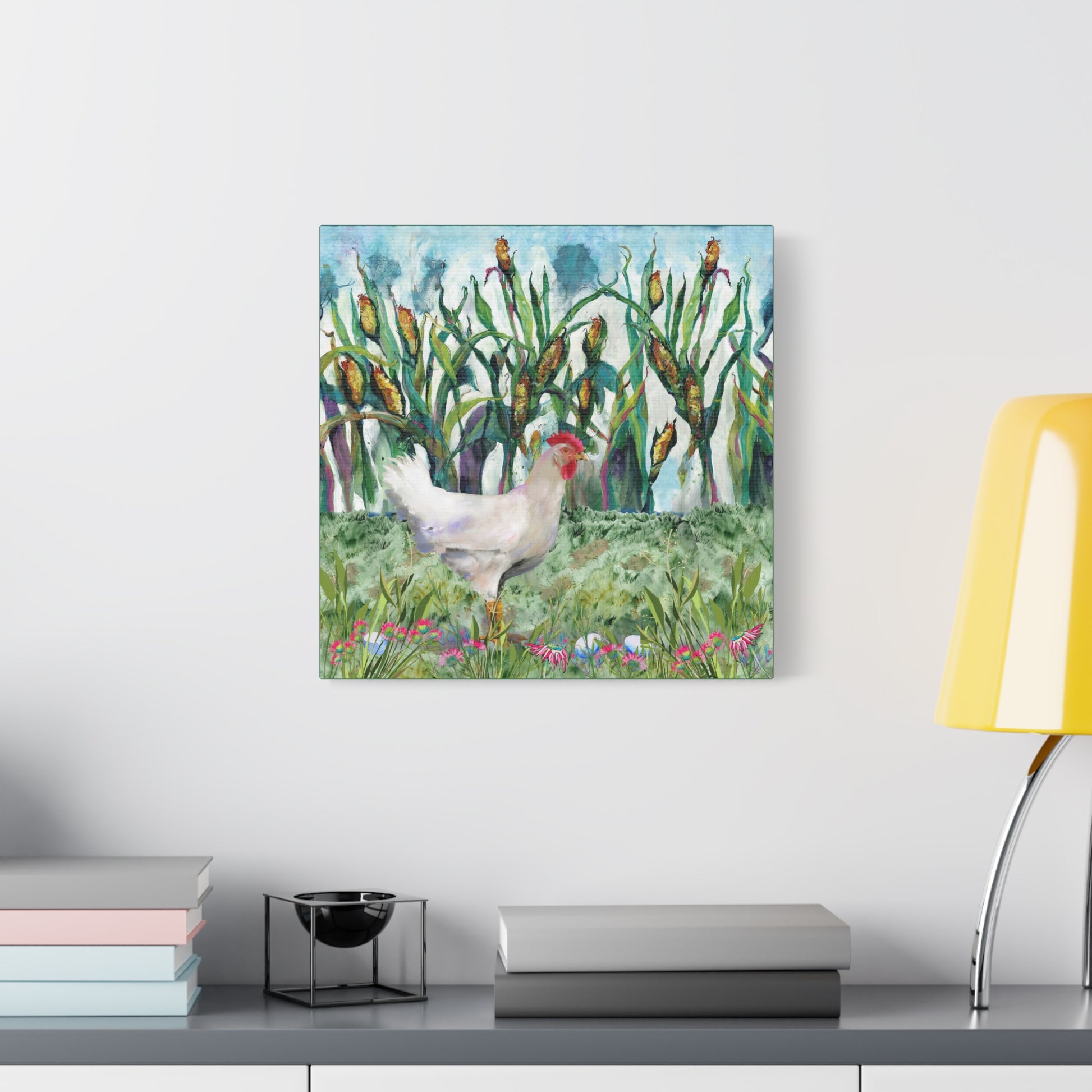 Canvas print of a chicken in a field with corn on a wall above a desk.