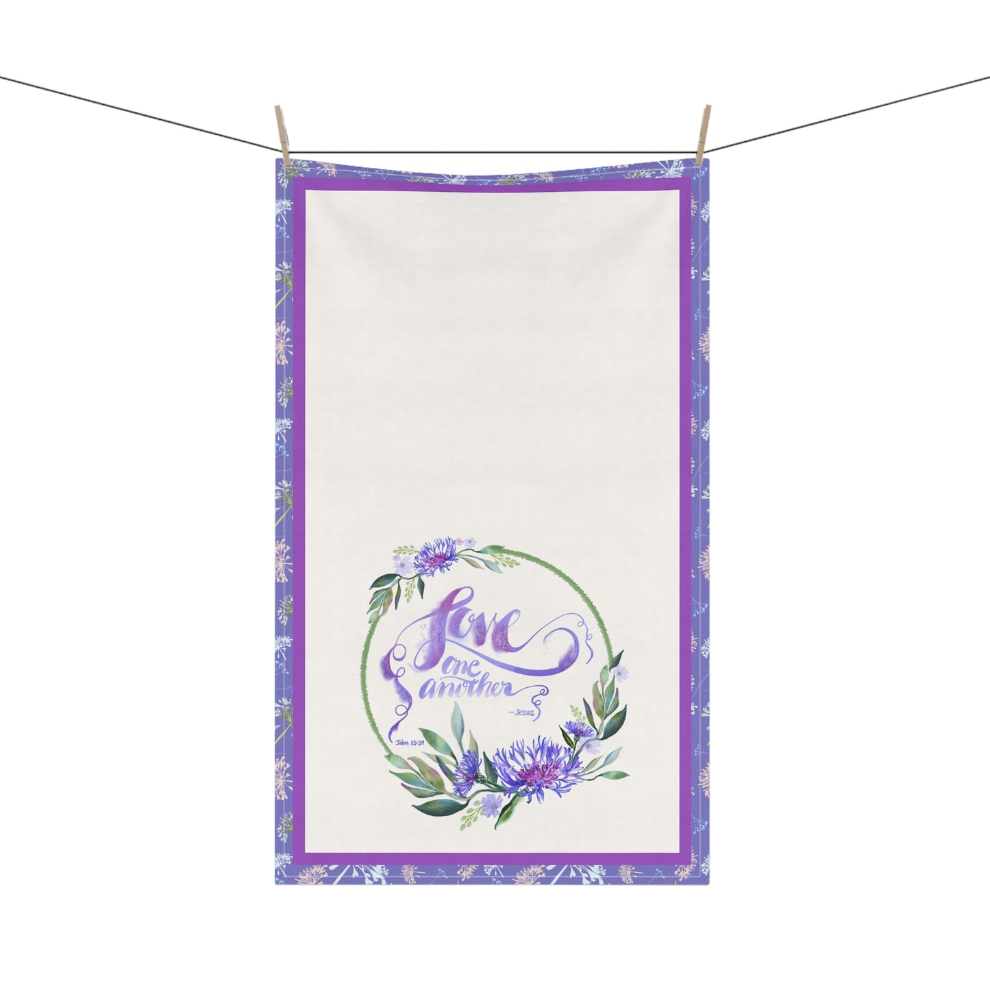 Decorative kitchen tea towel with floral design and 'Love One Another' text on a white background