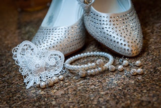 Lucky Wedding Penny next to Silver studded shoes with pearls on a textured surface