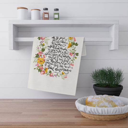 Decorative tea towel with floral and calligraphy Bible verse "If my people" hanging on a wall in a kitchen setting.